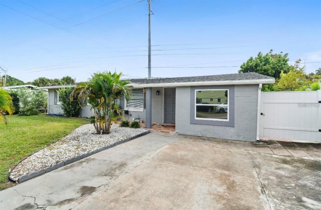 A gray, single-story concrete block house with a concrete driveway and a white privacy fence — 3906 DOANE STREET, ORLANDO, FL