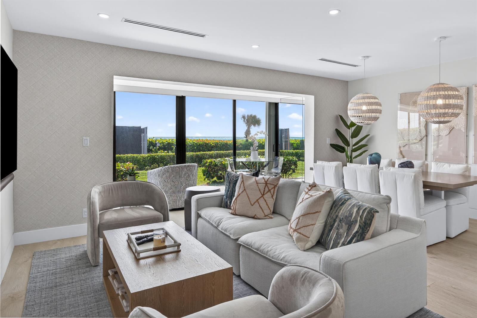 A living and dining area features neutral furniture, a wooden coffee table, and ocean views — 5720 Old Ocean Boulevard # 5e, Ocean Ridge FL 33435, OCEAN RIDGE, FL