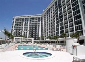 A large multi-story apartment building overlooks a swimming pool and a circular hot tub — 10275 Collins Ave # 1435, Bal Harbour FL 33154, BAL HARBOUR, FL