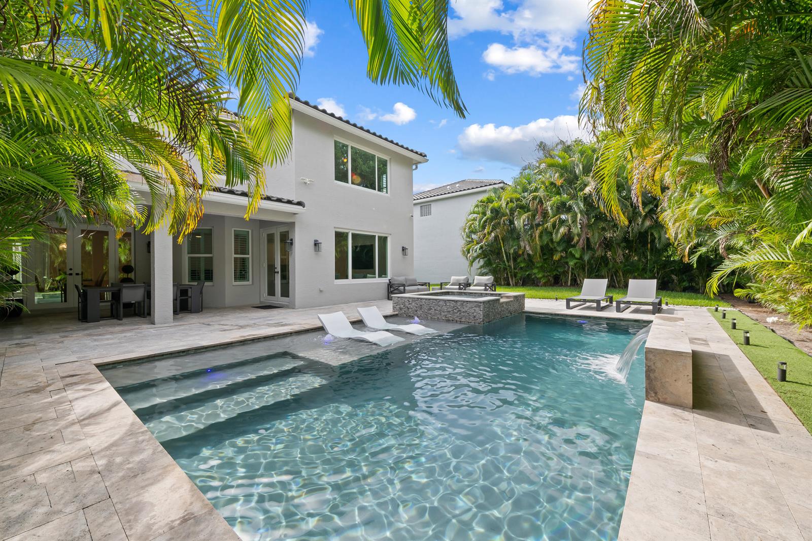 A two-story house features a backyard swimming pool with a tanning ledge and attached spa — 10560 Walnut Valley Drive, Boynton Beach FL 33473, BOYNTON BEACH, FL