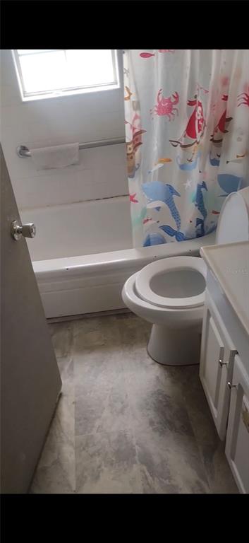 A bathroom features a white bathtub with a grab bar, a toilet, and a vanity — 1124 ALABAMA STREET, TALLAHASSEE, FL