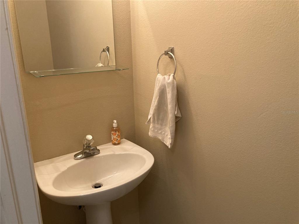 A pedestal sink with a chrome faucet and a wall-mounted towel ring in a bathroom — 2533 HARN BOULEVARD UNIT 2, CLEARWATER, FL