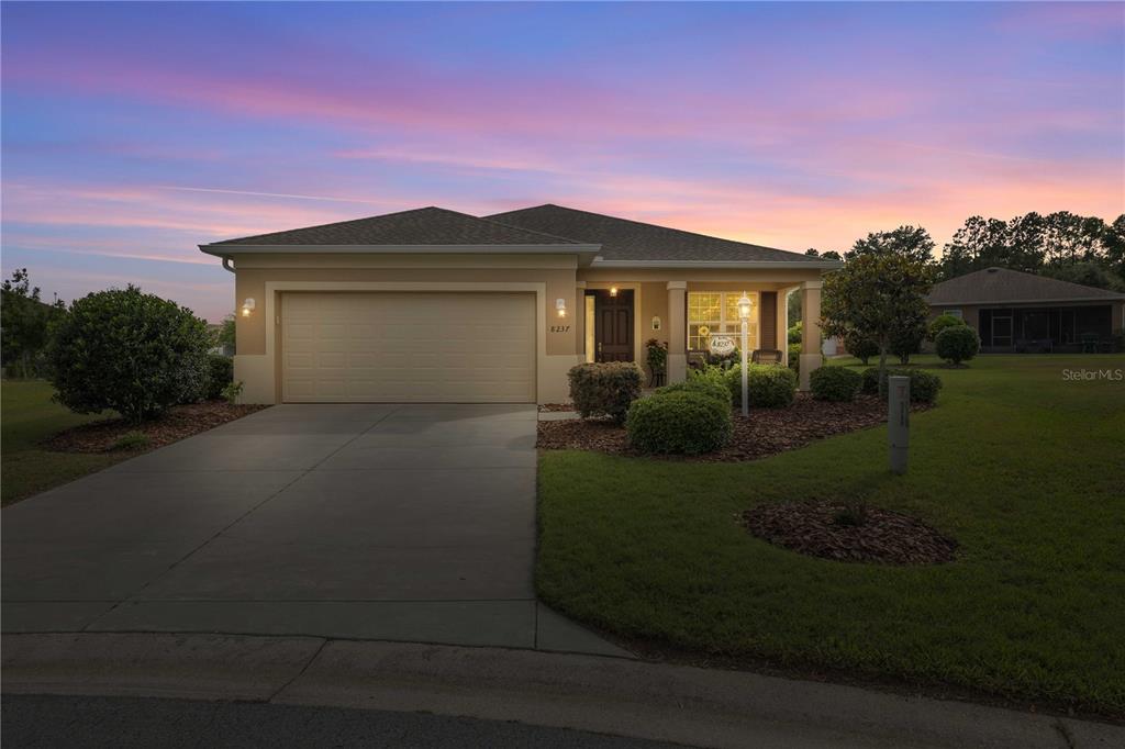 A single-story house with a beige exterior, a two-car garage, and a landscaped front yard — 8237 SW 78TH TERRACE ROAD, OCALA, FL