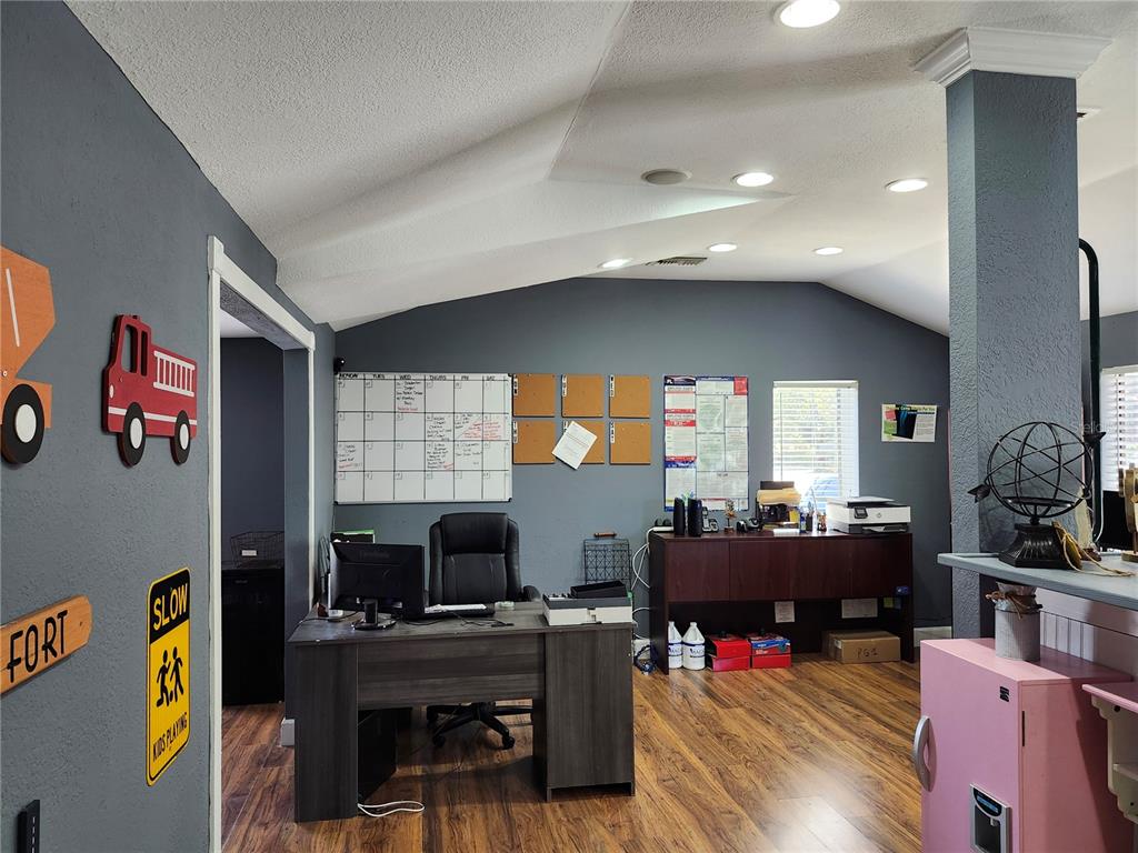 A home office features a dark wood desk, a wall calendar, and gray walls — 1901 W SLIGH AVENUE, TAMPA, FL