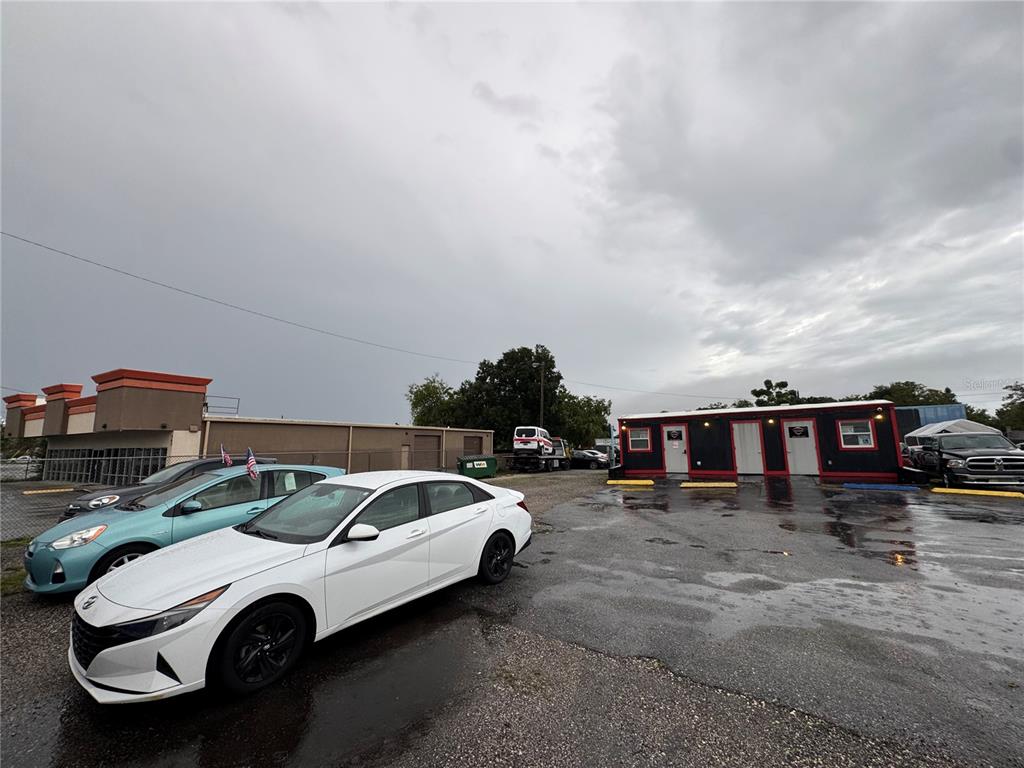 A white sedan is parked in a wet lot in front of a small office building — 575 N US HIGHWAY 17 92, LONGWOOD, FL