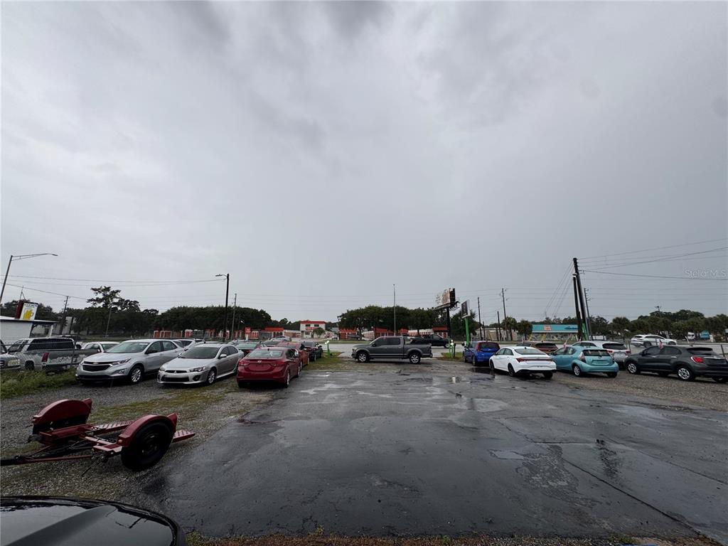 A car dealership lot features multiple parked vehicles under a cloudy, overcast sky — 575 N US HIGHWAY 17 92, LONGWOOD, FL