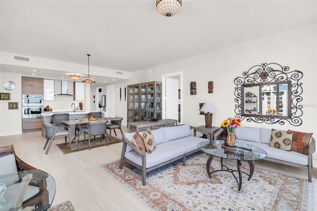 An open-concept living and dining area features light wood floors, neutral walls, and modern furniture — 301 1ST STREET S UNIT 3305, ST PETERSBURG, FL