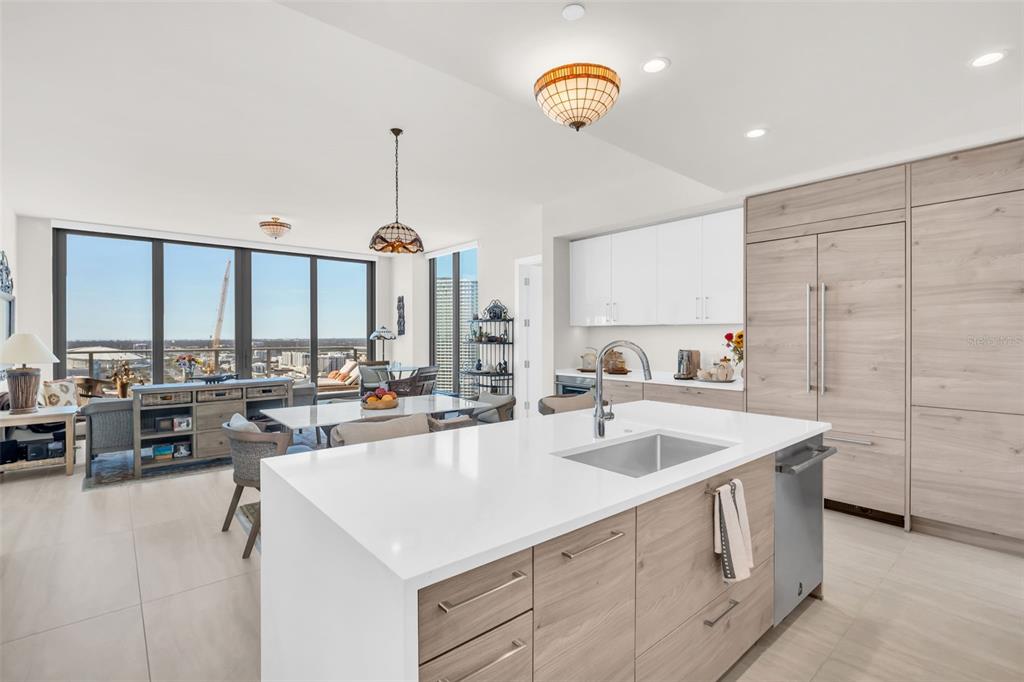 A modern kitchen with a white island, light wood cabinetry, and an open living area — 301 1ST STREET S UNIT 3305, ST PETERSBURG, FL