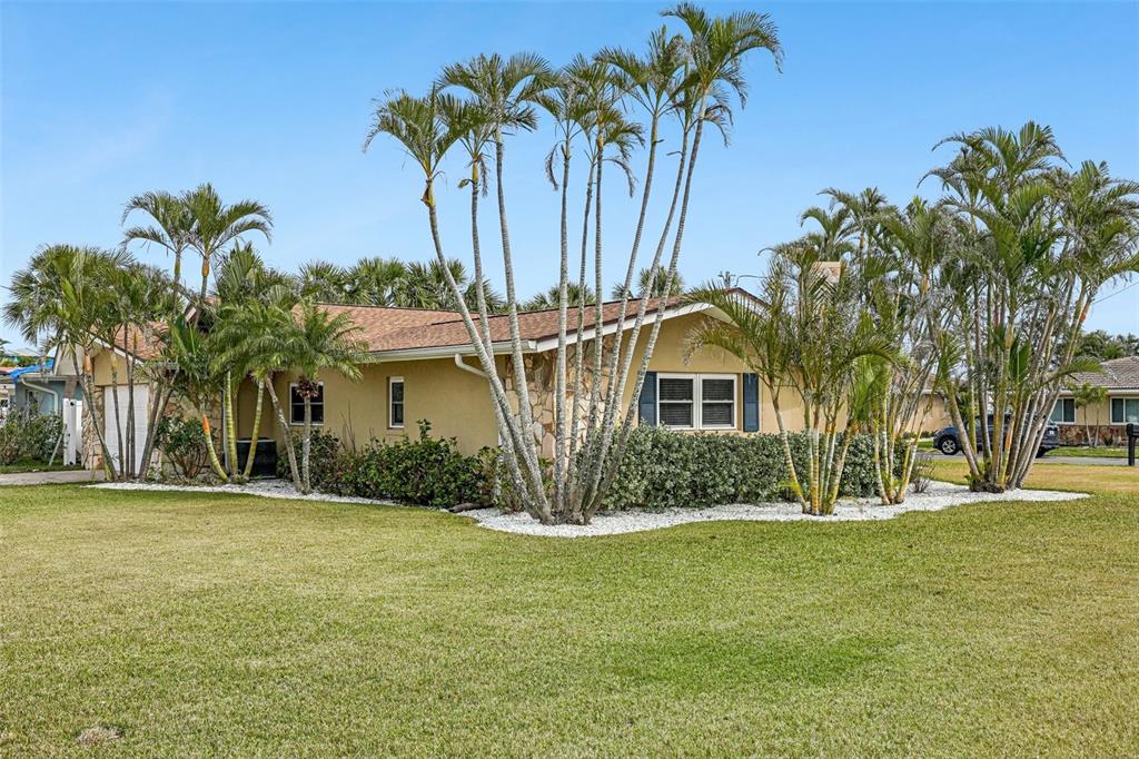 An aerial view shows a waterfront neighborhood with a highlighted house on a corner lot — 5815 BALI WAY S, ST PETE BEACH, FL