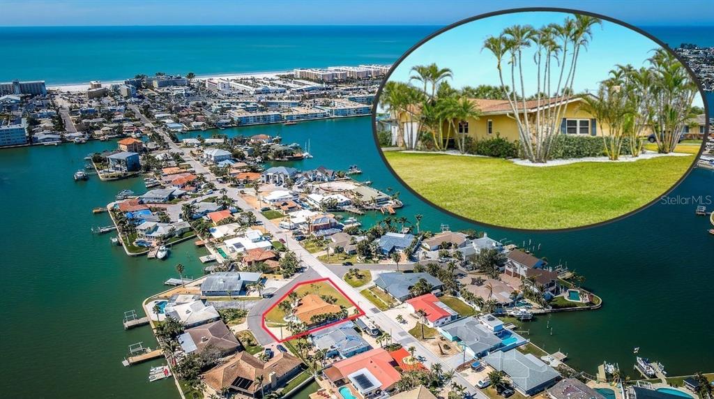 A single-story house with a stone facade, a teal front door, and a palm-filled yard — 5815 BALI WAY S, ST PETE BEACH, FL