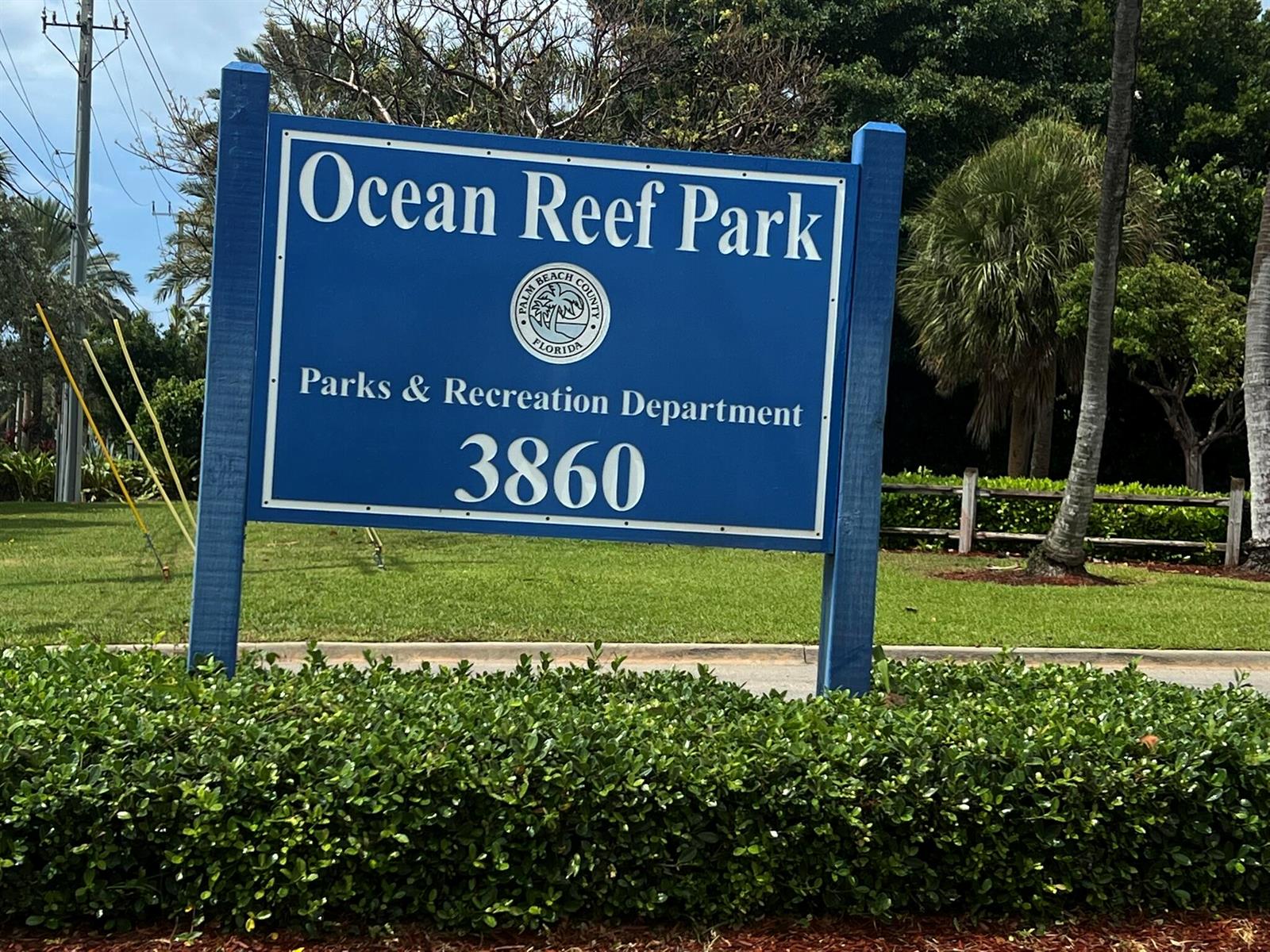 A blue sign for Ocean Reef Park stands in a grassy area with trees — 1260 Manor Drive, Riviera Beach FL 33404, RIVIERA BEACH, FL