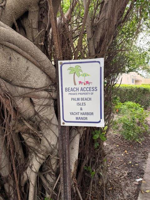 A sign attached to a tree trunk indicates private beach access for Palm Beach Isles — 1260 Manor Drive, Riviera Beach FL 33404, RIVIERA BEACH, FL