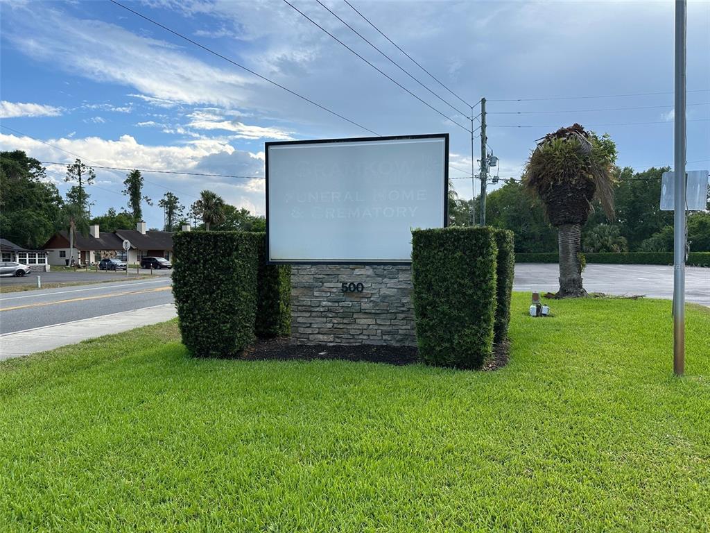 A sign for a funeral home and crematory stands in a grassy lot — 500 E AIRPORT BOULEVARD, SANFORD, FL