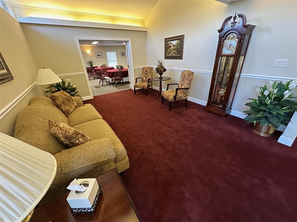 A living room features a tan sofa, two patterned chairs, and a tall grandfather clock — 500 E AIRPORT BOULEVARD, SANFORD, FL