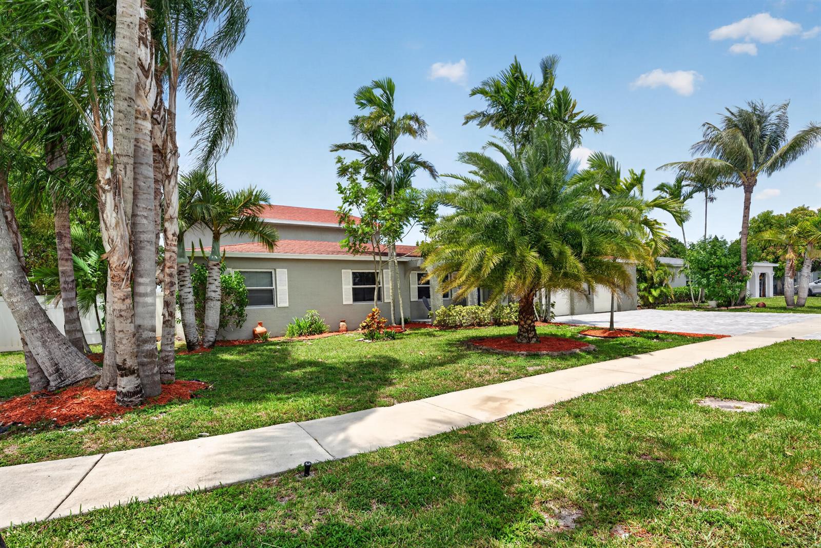 A single-story house with a red roof and palm trees sits behind a concrete sidewalk — 10941 Granite Street, Boca Raton FL 33428, BOCA RATON, FL