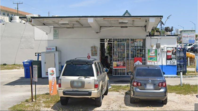 A small commercial building with a flat roof, parking spaces, and a gated storefront entrance — 1301 E COMMERCIAL BOULEVARD, OAKLAND PARK, FL
