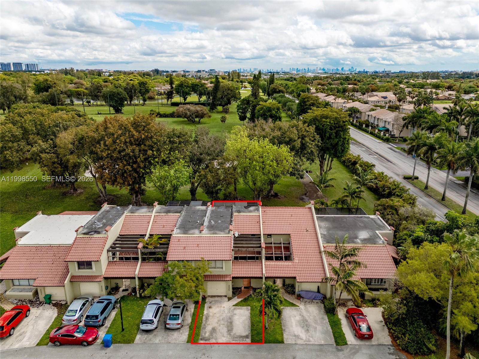 An aerial view shows a row of townhouses with red-tiled roofs and driveways — 3325 Torremolinos Ave # 44, Doral FL 33178, DORAL, FL