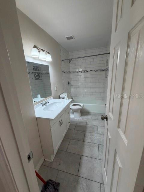 A bathroom with a white vanity, a toilet, and a shower-tub combo with white subway tile — 7487 CANFORD COURT UNIT 5, WINTER PARK, FL