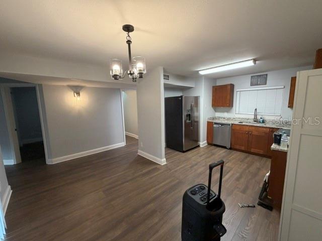 A kitchen with wood cabinets, stainless steel appliances, and dark wood-look flooring — 7487 CANFORD COURT UNIT 5, WINTER PARK, FL