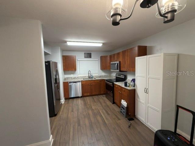A kitchen features wood cabinets, stainless steel appliances, and wood-look flooring — 7487 CANFORD COURT UNIT 5, WINTER PARK, FL