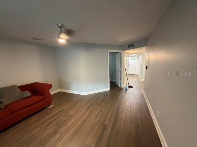 A living room features light gray walls, wood-look flooring, a ceiling fan, and a red sofa — 7487 CANFORD COURT UNIT 5, WINTER PARK, FL