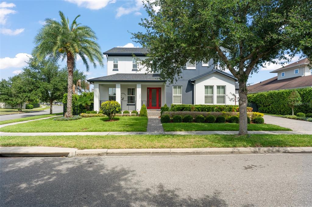 A two-story house with a red front door, a palm tree, and a manicured lawn — 12664 BANTING TERRACE, ORLANDO, FL