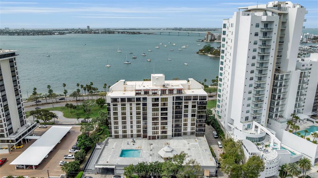 An aerial view shows three high-rise apartment buildings near a bay with many boats — 707 S GULFSTREAM AVENUE UNIT 802, SARASOTA, FL
