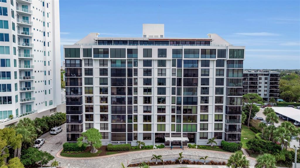 A multi-story residential building with a white facade and dark-framed windows stands outdoors — 707 S GULFSTREAM AVENUE UNIT 802, SARASOTA, FL