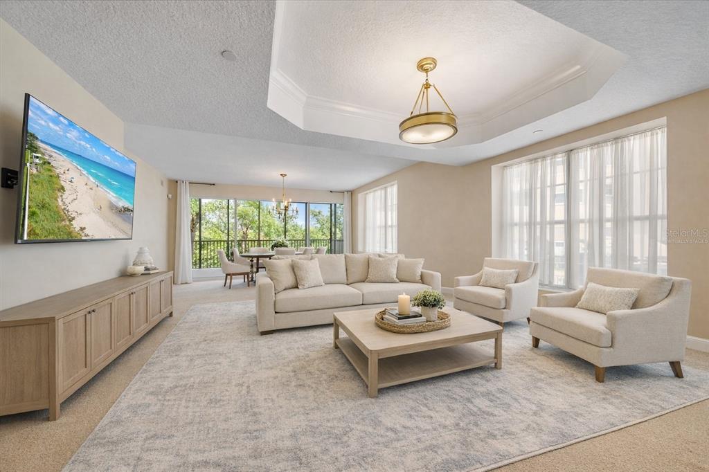 A living room with a beige sofa, two armchairs, a coffee table, and a television — 6482 WATERCREST WAY UNIT 204, LAKEWOOD RANCH, FL