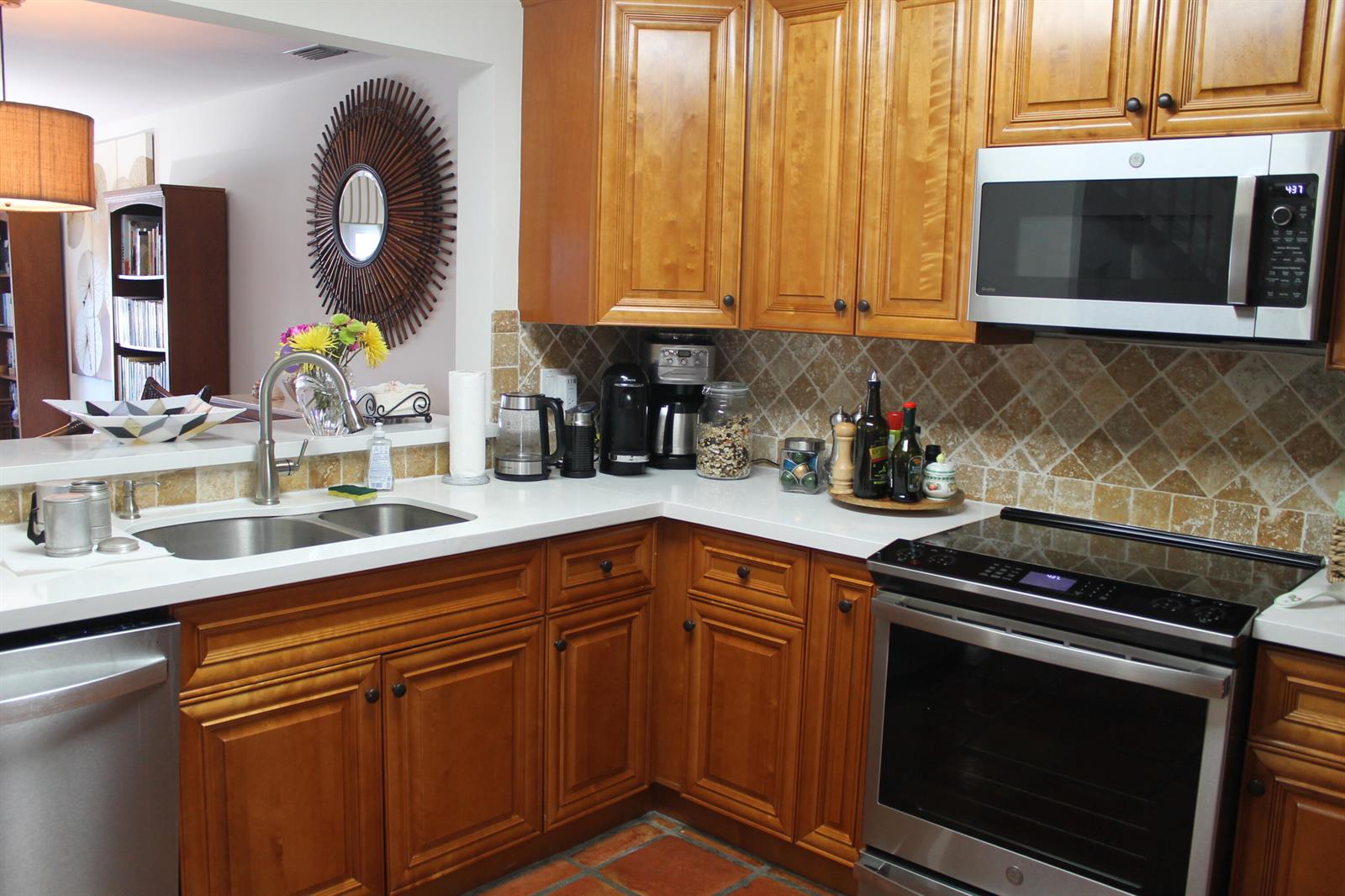 A kitchen with wood cabinets, stainless steel appliances, a white countertop, and a tiled backsplash — 1120 Ocean Dunes Circle, Jupiter FL 33477, JUPITER, FL