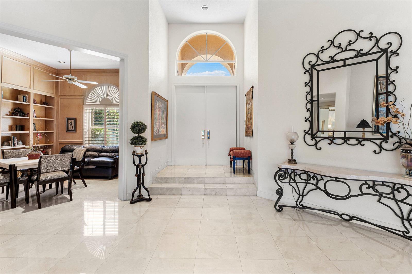 A bright foyer with white tile floors, a double door entrance, and an arched window — 17571 Bocaire Way, Boca Raton FL 33487, BOCA RATON, FL