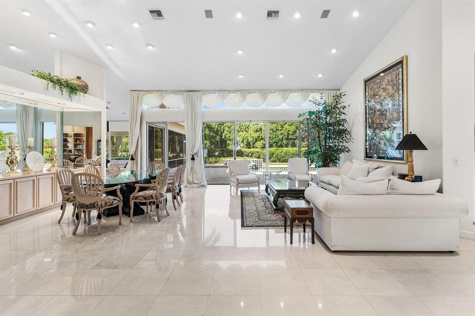 A bright, open-concept living and dining area features white tile floors and large glass doors — 17571 Bocaire Way, Boca Raton FL 33487, BOCA RATON, FL