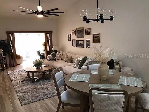 An open-concept living and dining area features a sectional sofa, round table, and ceiling fan — 1423A OAK PLACE, APOPKA, FL