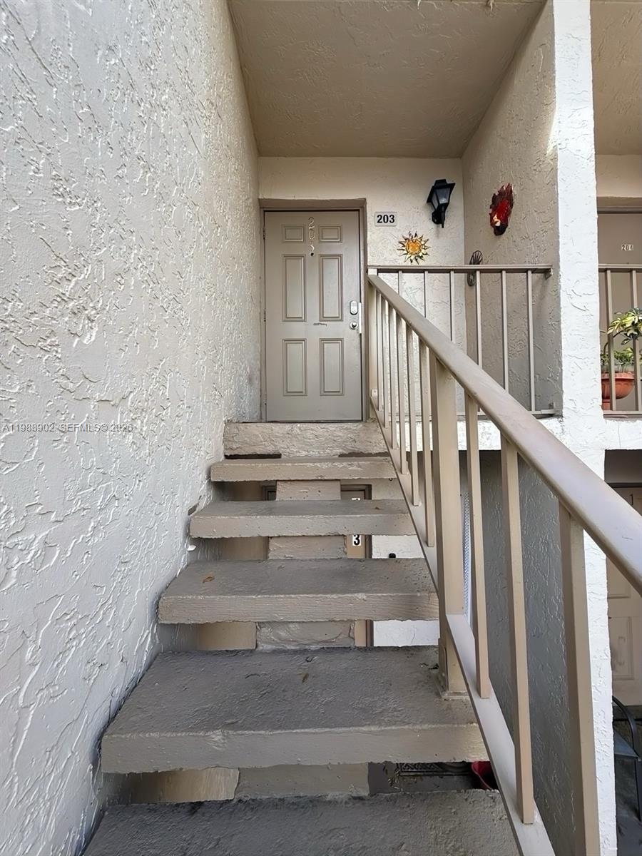 An exterior staircase leads to the entrance of a second-story apartment unit — 1040 NW 80th Ave # 203, Margate FL 33063, MARGATE, FL