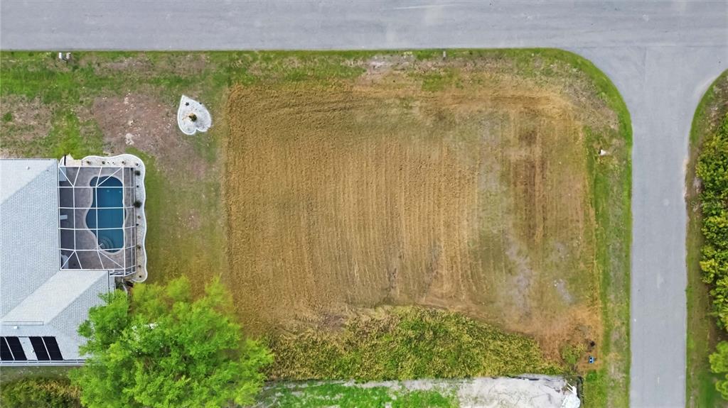 An aerial view shows a vacant, cleared residential lot next to a house with a pool — ATTALLA AVENUE, NORTH PORT, FL