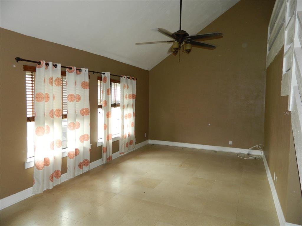 An empty room features tan walls, tile flooring, a vaulted ceiling, and a ceiling fan — 266 ORIENTA POINT STREET, ALTAMONTE SPRINGS, FL