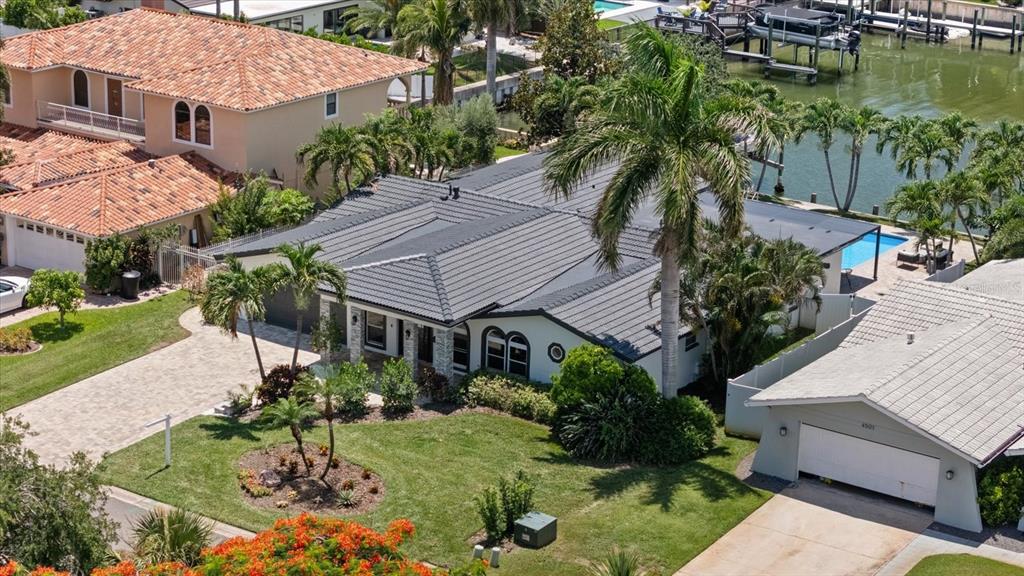 An aerial view shows a single-story house with a gray roof, palm trees, and pool — 4531 44TH STREET S, ST PETERSBURG, FL