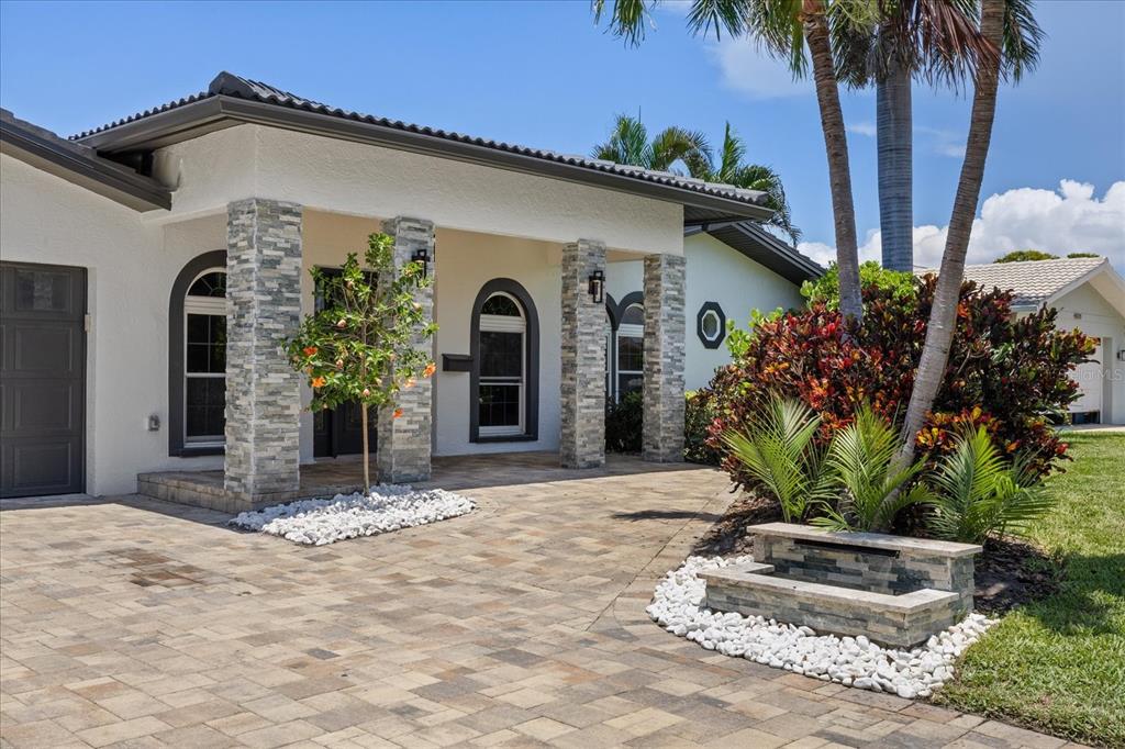 The exterior of a house features a stone-paved driveway, stone columns, and a small fountain — 4531 44TH STREET S, ST PETERSBURG, FL