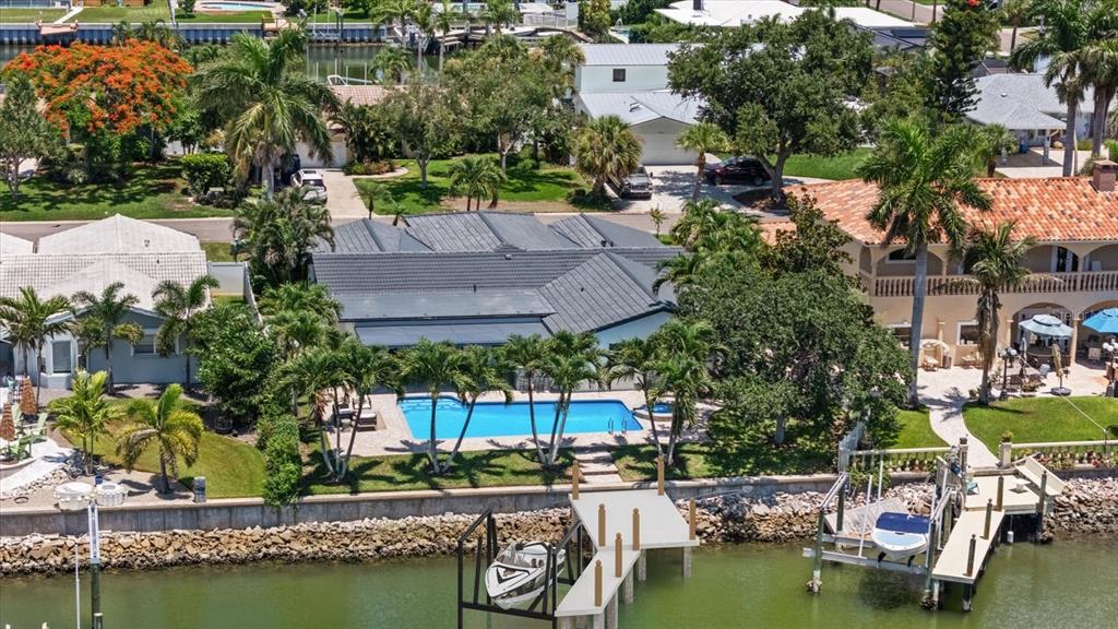 An aerial view of a waterfront house featuring a swimming pool, dock, and boat lift — 4531 44TH STREET S, ST PETERSBURG, FL