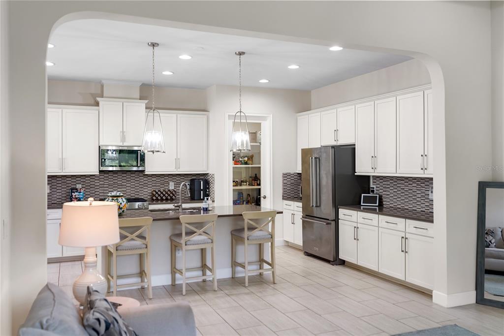 A kitchen with white cabinets, stainless steel appliances, a center island, and a walk-in pantry — 2312 STARWOOD COURT, BRADENTON, FL