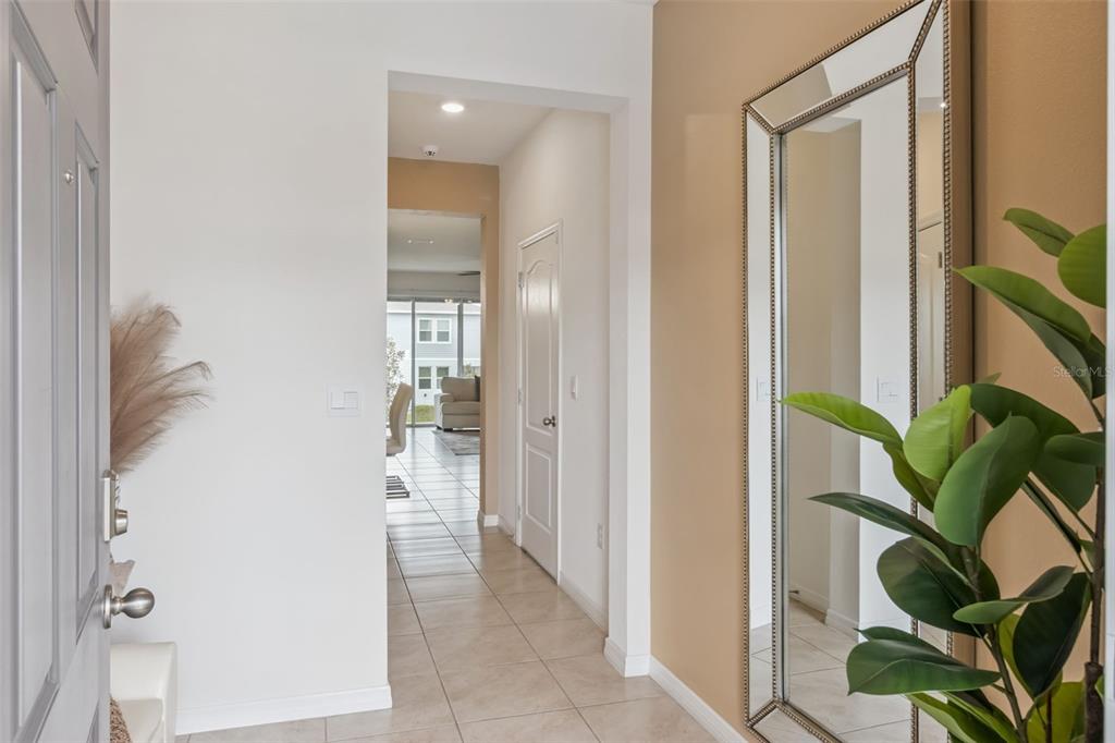 An entryway with tile flooring, a large wall mirror, and a view into the home — 1707 WOODEN STREET, DAVENPORT, FL