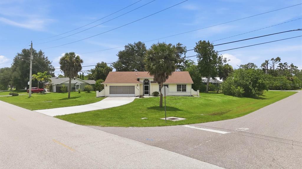 A single-story house with a light-colored exterior, a brown roof, and a concrete driveway — 5534 DAVID BOULEVARD, PORT CHARLOTTE, FL