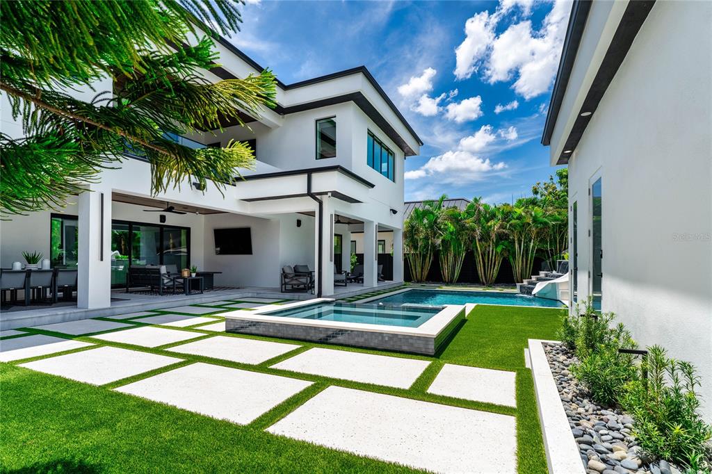 A modern two-story house with a backyard pool, spa, and paved patio area — 5002 W POE AVENUE, TAMPA, FL