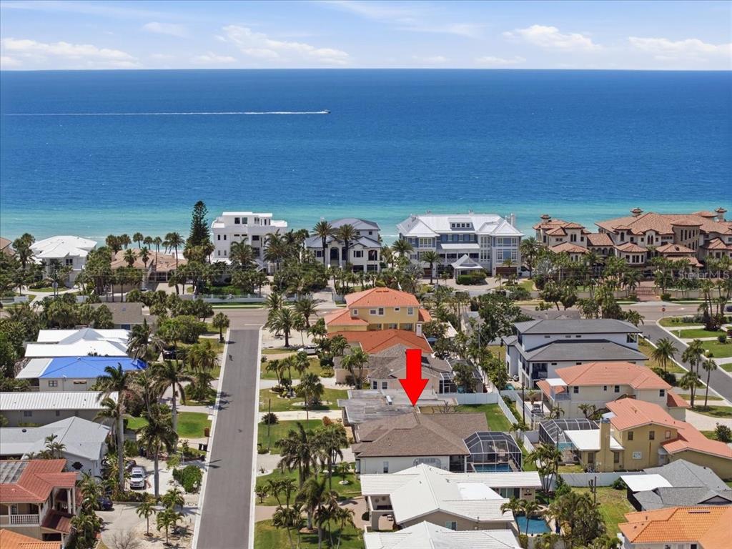 An aerial view shows a coastal neighborhood with a red arrow pointing to a house — 109 16TH STREET, BELLEAIR BEACH, FL