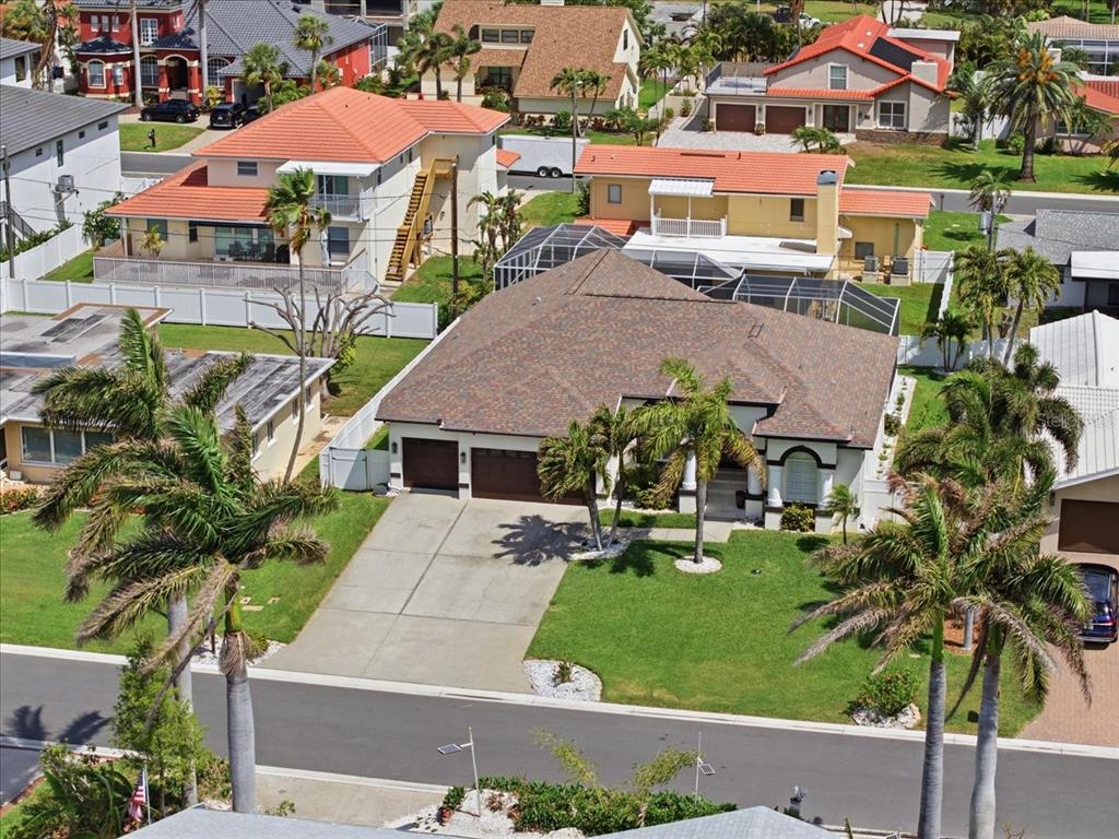 An aerial view of a suburban house with a brown roof, driveway, and palm trees — 109 16TH STREET, BELLEAIR BEACH, FL