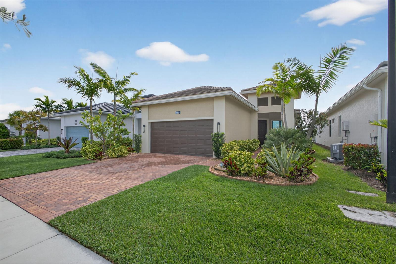 A single-story suburban house with a brick driveway, brown garage door, and palm trees — 4805 Saint Armands Way, Westlake FL 33470, WESTLAKE, FL