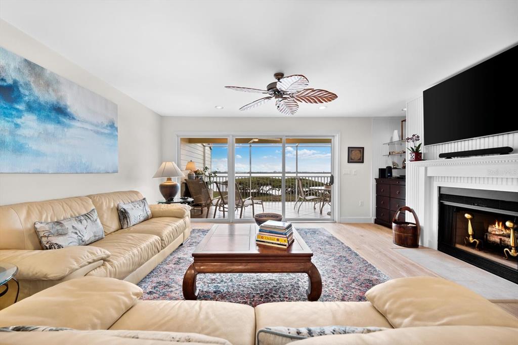 A living room features a tan leather sofa, a wooden coffee table, and a fireplace — 71 TIDY ISLAND BOULEVARD, BRADENTON, FL