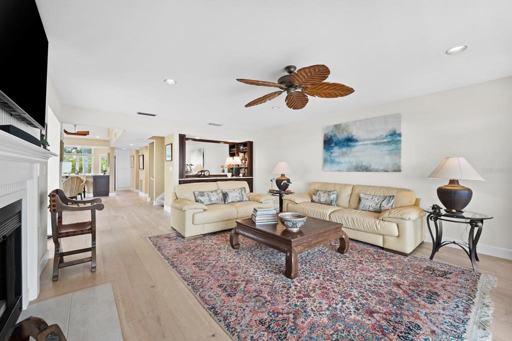 A living room features light wood floors, two beige sofas, a patterned rug, and a ceiling fan — 71 TIDY ISLAND BOULEVARD, BRADENTON, FL