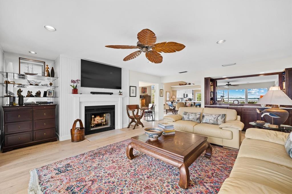 A living room features a fireplace, a ceiling fan, and a large patterned area rug — 71 TIDY ISLAND BOULEVARD, BRADENTON, FL