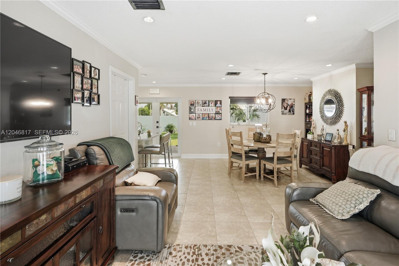 A living and dining area with tile floors, a television, and a round wooden table — 10451 SW 201st Ter, Cutler Bay FL 33189, CUTLER BAY, FL